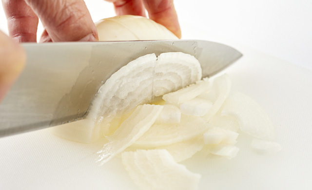 生の新玉ねぎを薄切りにしている写真