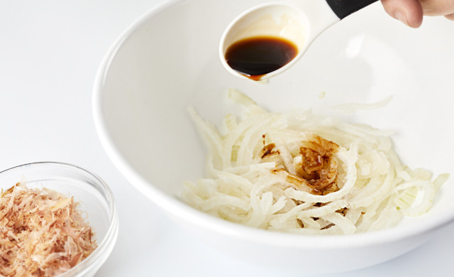 冷凍した新玉ねぎの薄切りにしょうゆをかけている写真