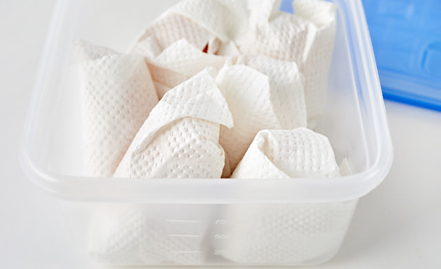 びわをキッチンペーパーで包んでいる写真