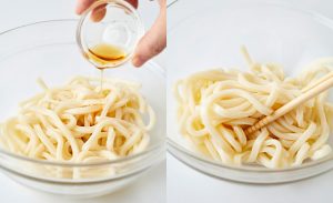 うどんにごま油をまぶしている写真