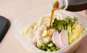 めんつゆをうどん弁当にかけている写真