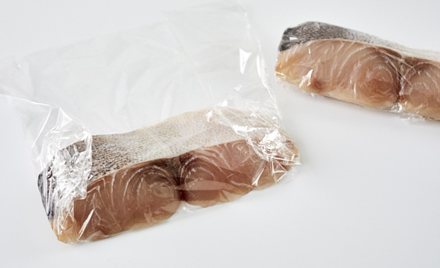 生のシイラをラップで包んでいる写真