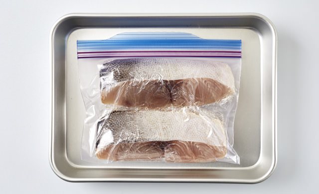 冷凍用保存袋に入れてバットの上に置いた生のシイラの写真