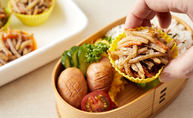 きんぴらごぼうを凍ったままお弁当箱に詰めている写真