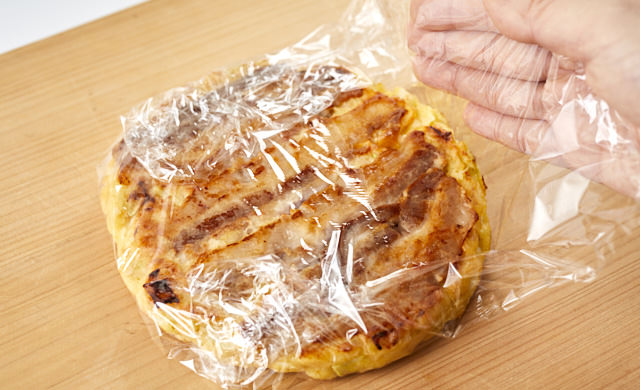 お好み焼きをラップで包んでいる写真