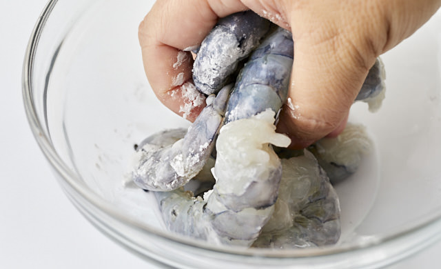 むきエビに塩と小麦粉をまぶしてもむ写真