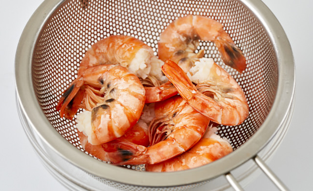 ゆでた殻付きエビをザルに上げた写真