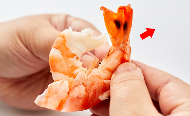 ゆでた殻付きエビの殻をむく写真