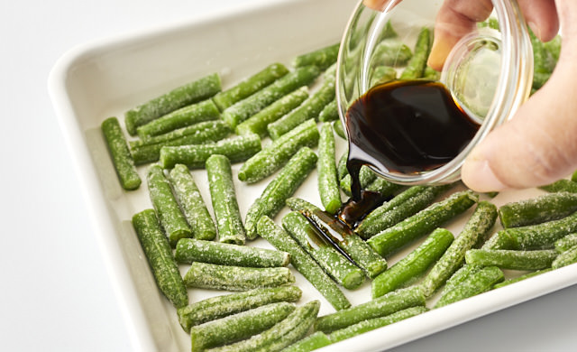 冷凍いんげんに醤油をかけている写真