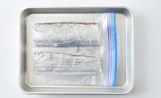 タチウオの切り身をラップで包み冷凍用保存袋に入れた写真