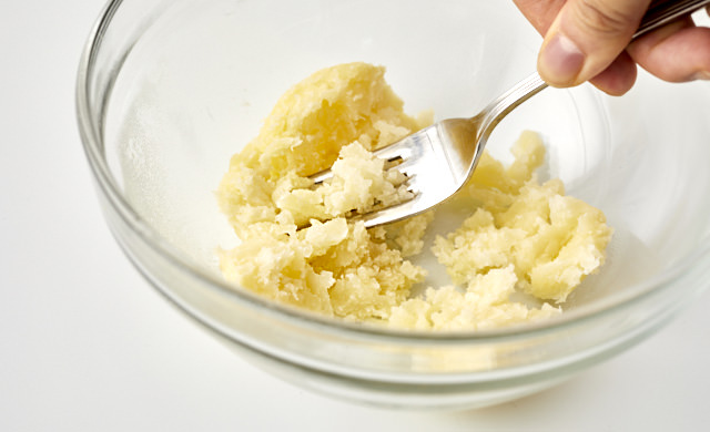 じゃがいもをフォークの背で潰している写真