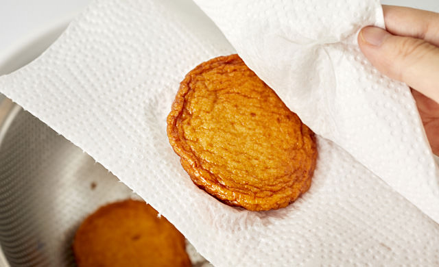 さつま揚げの水気をキッチンペーパーで拭き取っている写真