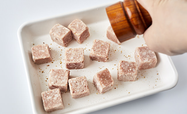 サイコロステーキにこしょうを振っている写真