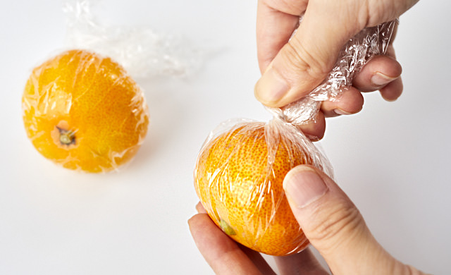 みかんをラップで包んでいる写真