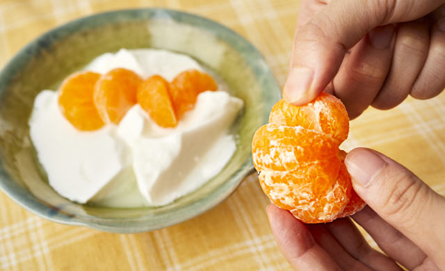 冷凍みかんをヨーグルトにのせている写真