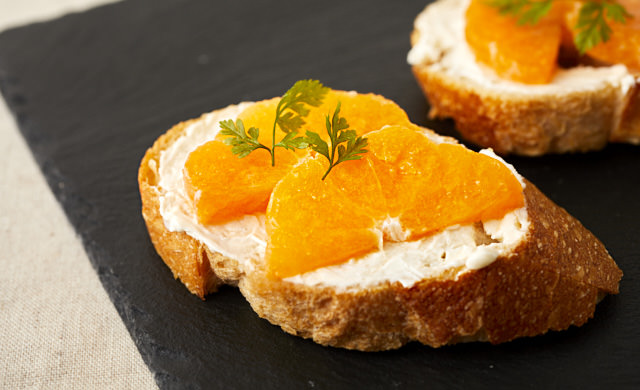 クリームチーズとみかんをのせたバゲットの写真