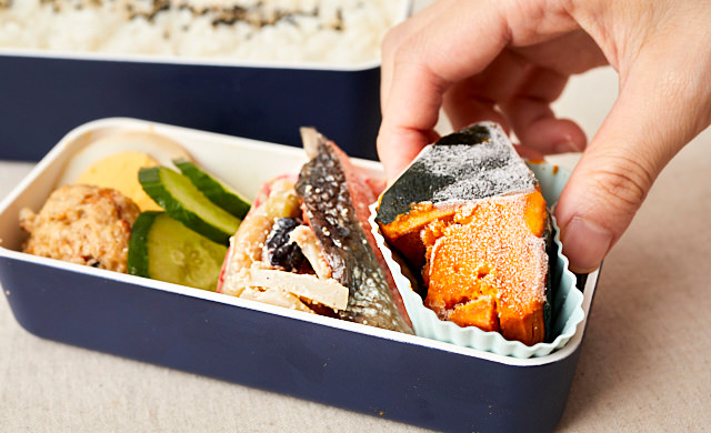 かぼちゃの煮物をお弁当に詰めている写真