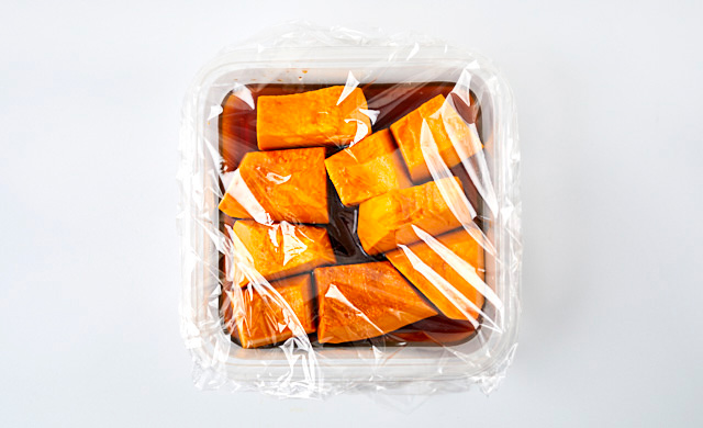 ラップをかけたかぼちゃの煮物の写真