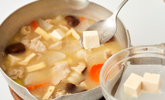 豚汁から豆腐を取り出している写真