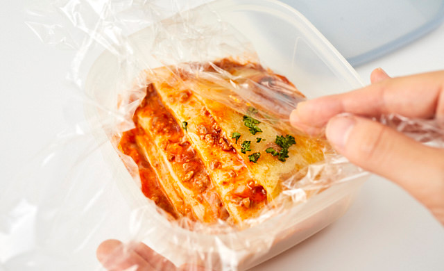 冷凍用保存容器にラザニアを入れている写真