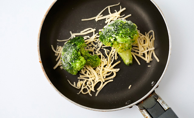 ブロッコリーとチーズをフライパンにのせている写真