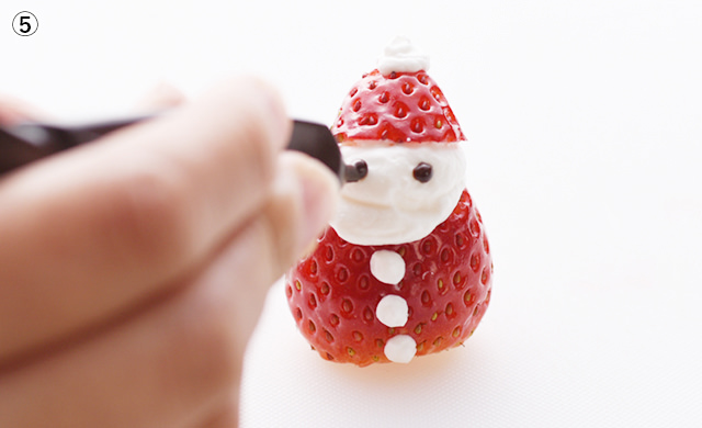 いちごサンタの目をチョコペンで描く