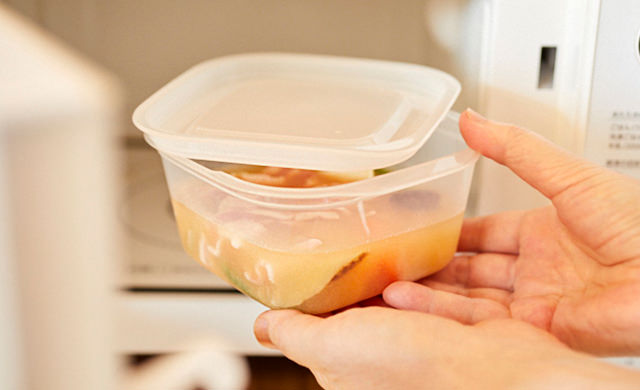 ふたをずらしてかぶせた耐熱容器を電子レンジに入れている様子