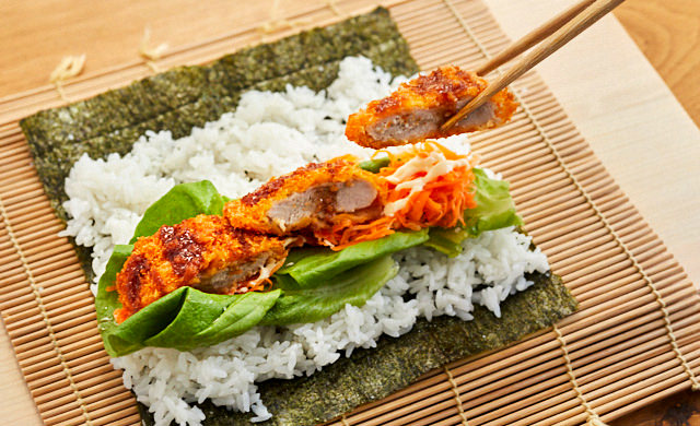 敷き詰めたごはんと具材の上に『極上ヒレかつ』をのせている様子