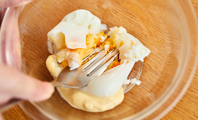 ゆで卵をフォークで潰し混ぜている様子