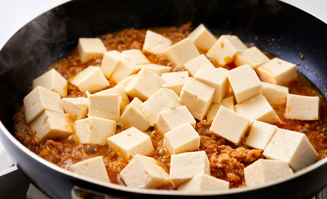 豆腐を加えている写真
