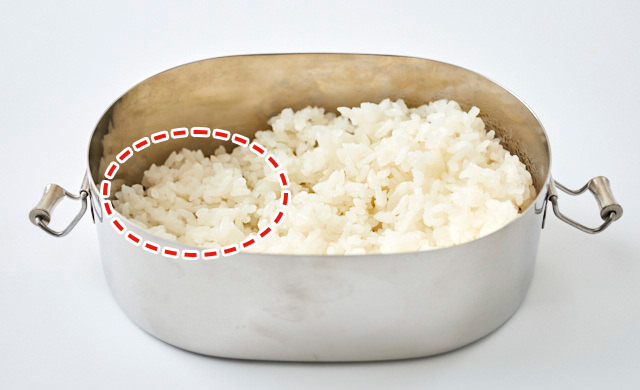 ロコモコ弁当のごはんを詰めている写真