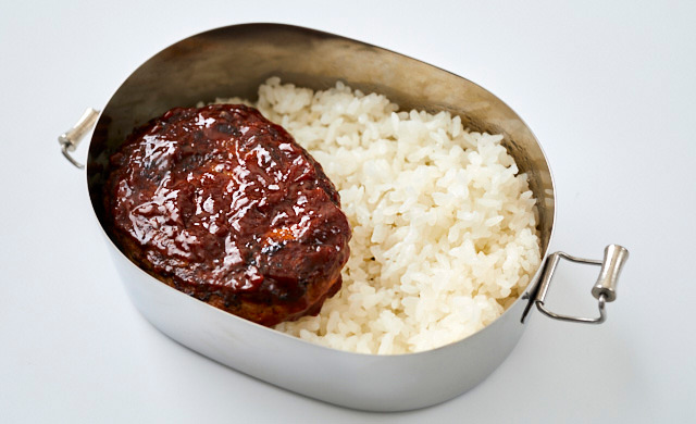 ロコモコ弁当にハンバーグをのせている写真