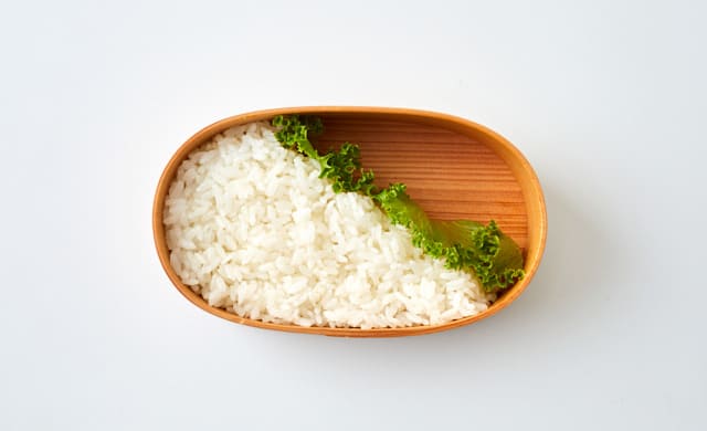 お弁当箱にごはんを詰めた写真