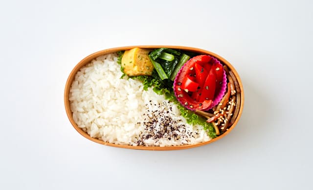 お弁当箱にごはんとおかずを詰めた写真