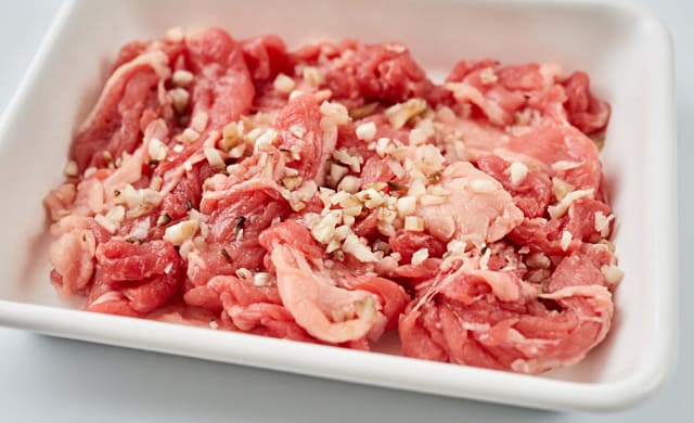 牛肉に舞茸をまぶしている写真