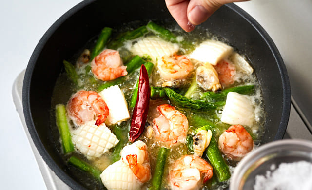 アヒージョに塩をふっている写真