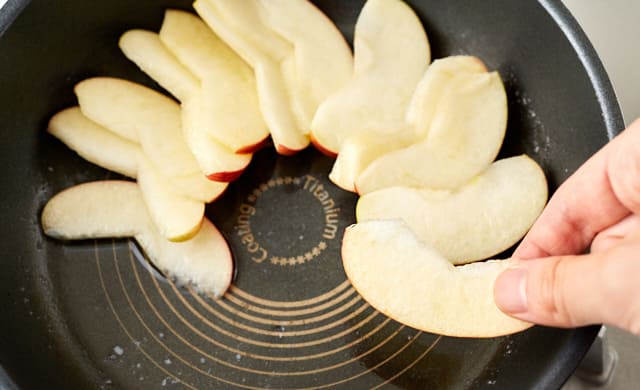フライパンにりんごを並べている写真