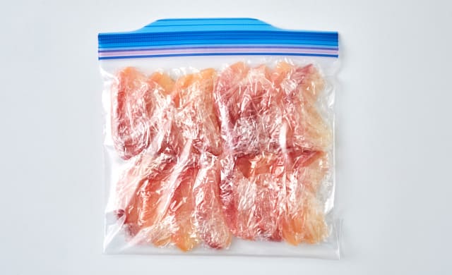 りんごのコンポートを冷凍用保存袋に入れている写真