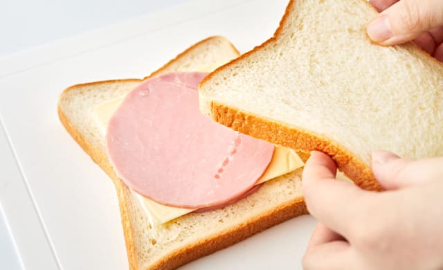 サンドイッチに具材を挟んでいる写真