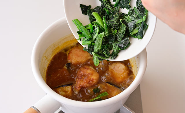 凍ったままの『そのまま使える 九州産のほうれん草』を鍋に入れている様子