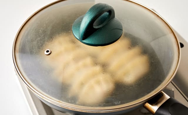 餃子を蒸し焼きにしている写真