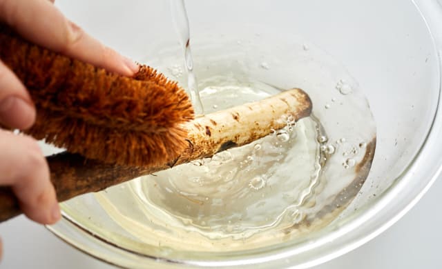 ごぼうの皮をたわしでこすっている写真