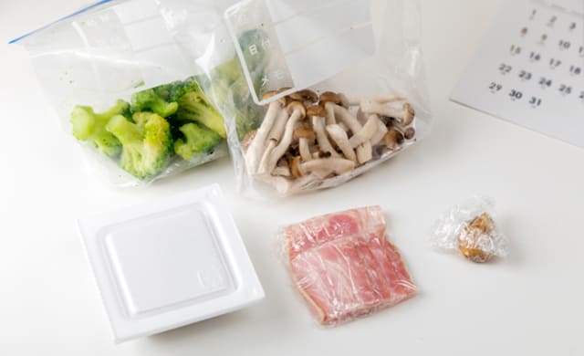 冷凍ごはん、使いかけの冷凍野菜などを並べている写真