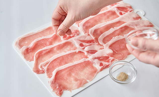 豚肉に塩をふっている写真