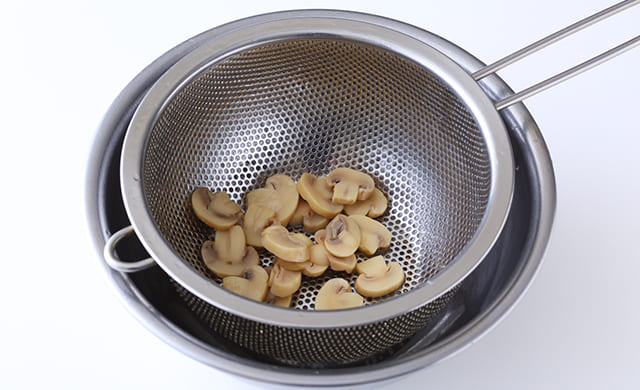 マッシュルームをザルにあげている写真