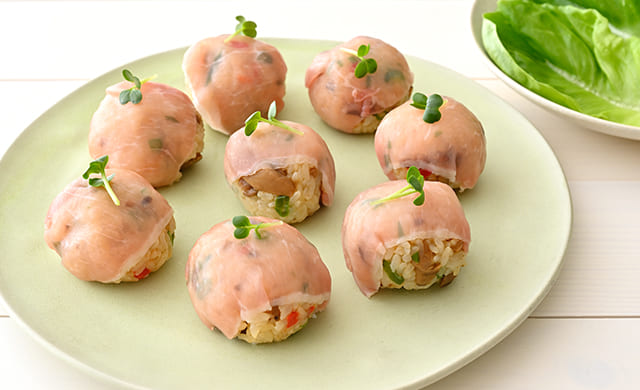 『焦がしバター醤油のきのこバターピラフ』の手まりおにぎりの生ハム巻きの写真