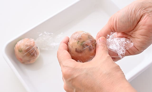 生ハムをのせて再度ラップで包んで丸くしている写真