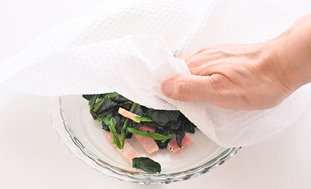 『ベーコンほうれん草』の水けをキッチンペーパーできっている写真