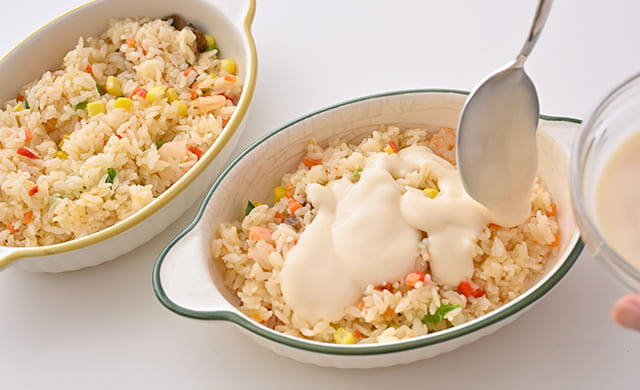 ピラフの上にホワイトソースをかけている写真