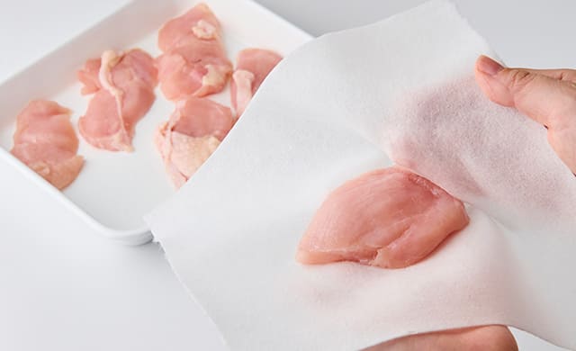 鶏肉の水気を拭き取っている写真
